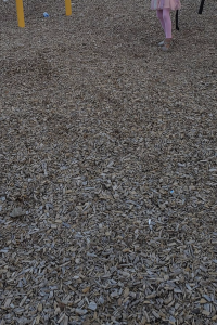 Photo of wood chips on a park playground. 