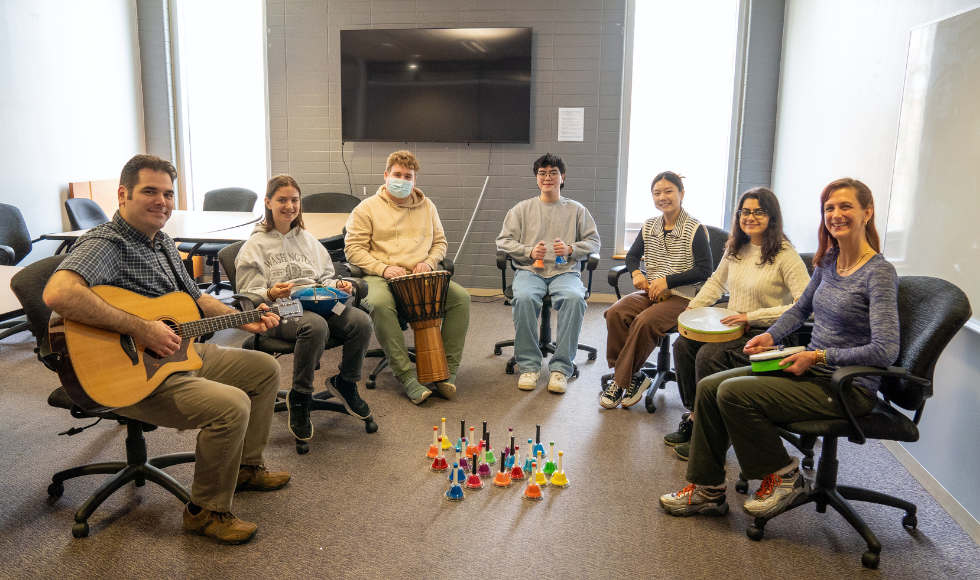 A group of students and researchers participating in music therapy.